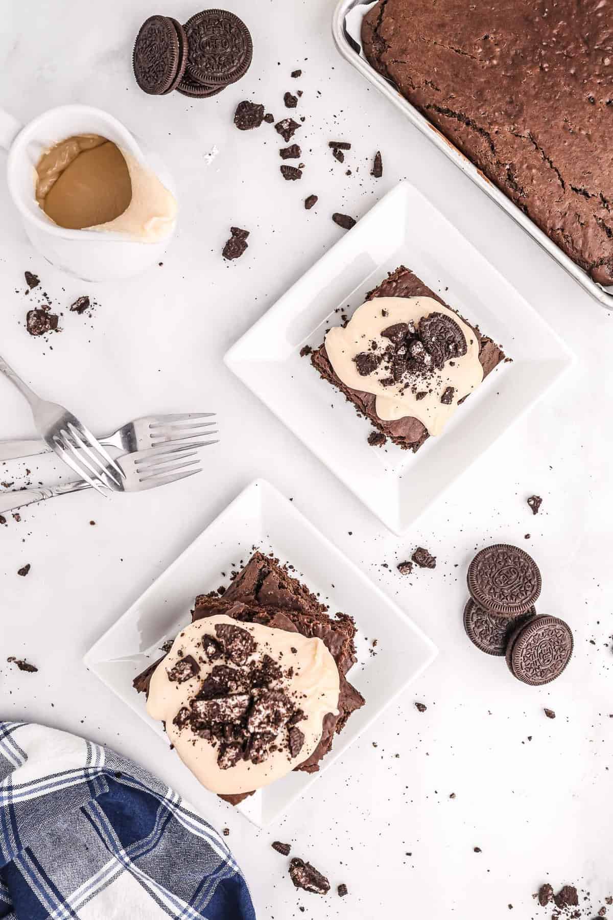 Vista aérea de dos platos de panqueques de oreo en bandeja, con oreos esparcidos alrededor.