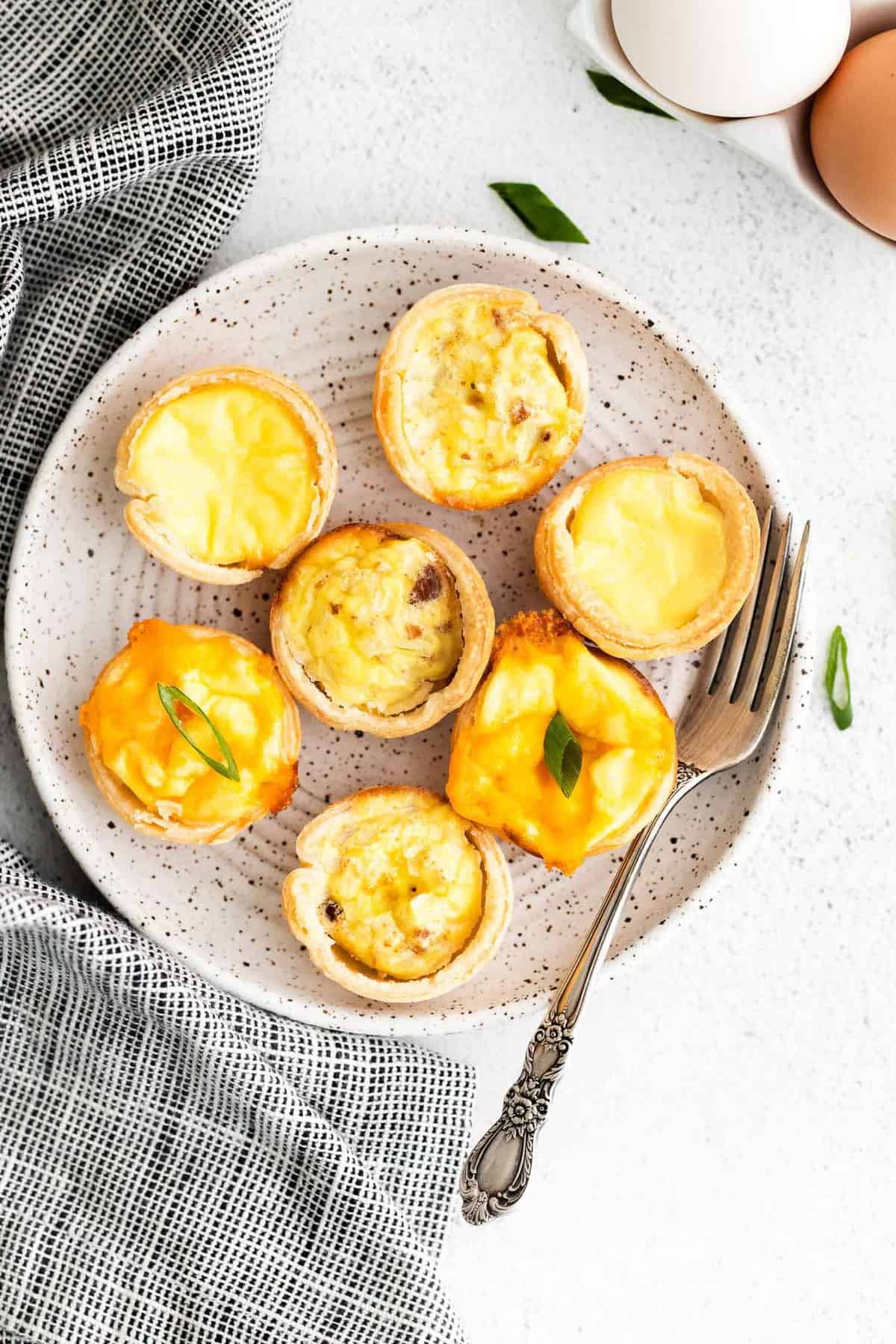 3 variedades de mini quiches en un plato redondo pequeño.