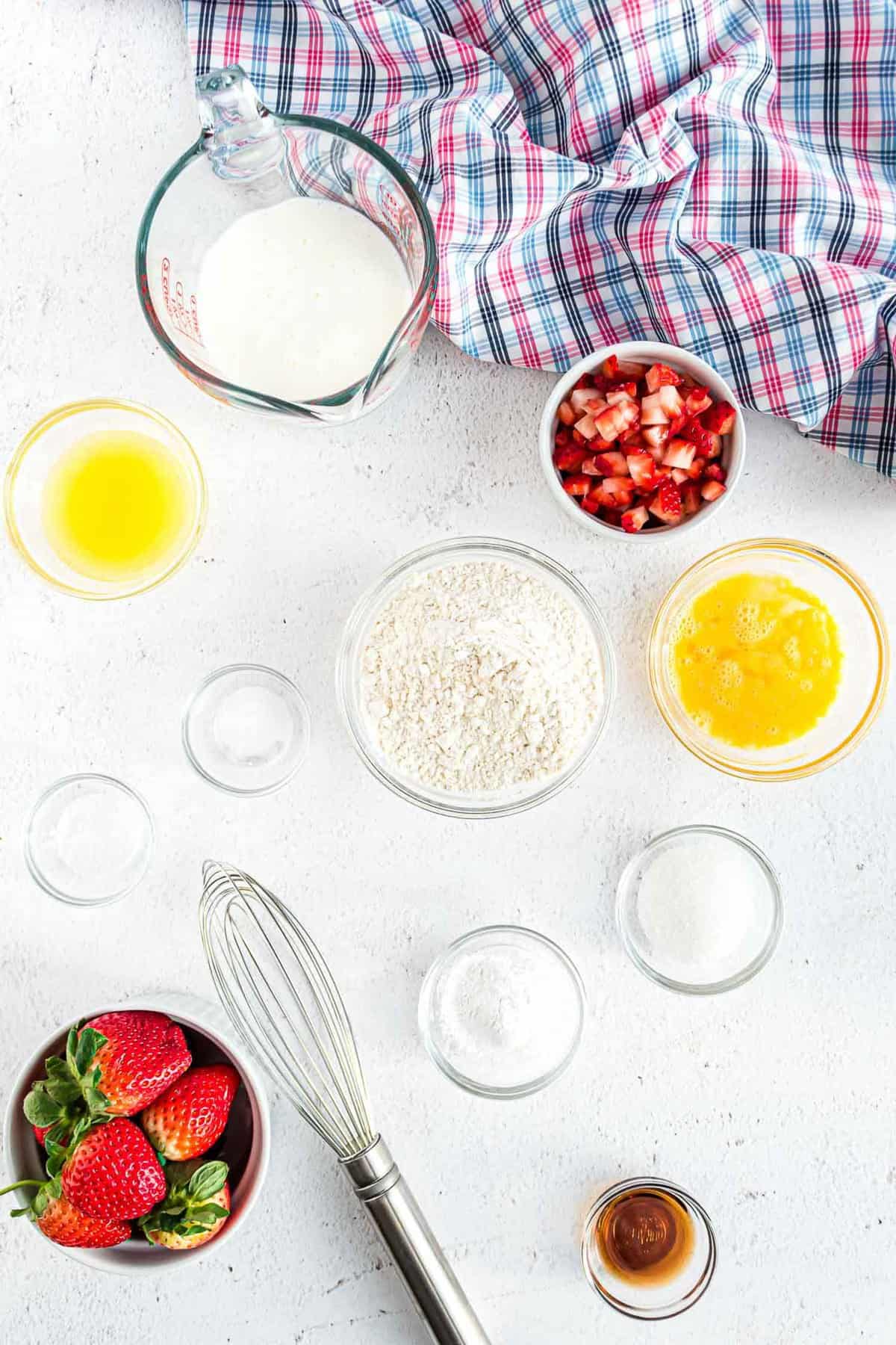 碗中食材的俯视图：草莓、面粉、黄油、香草等。