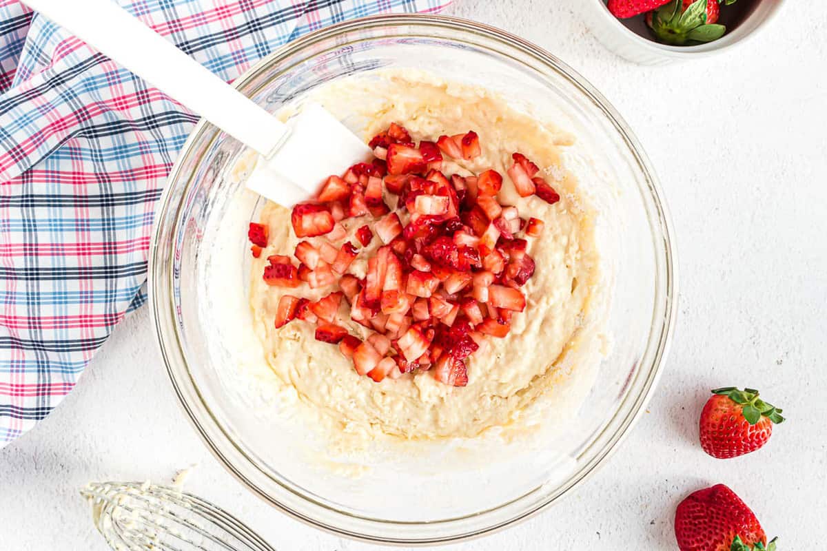 放在煎饼面糊上的切碎草莓。