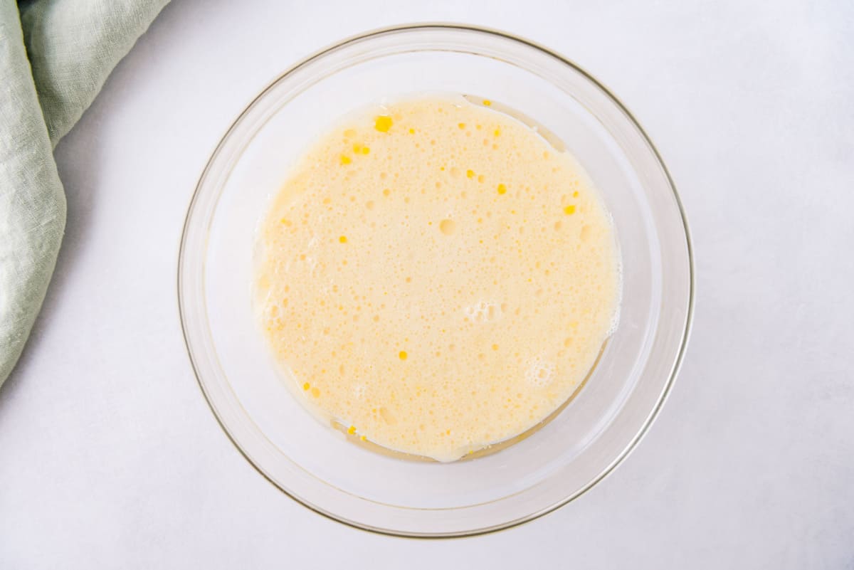 玻璃搅拌碗中的鸡蛋和奶。