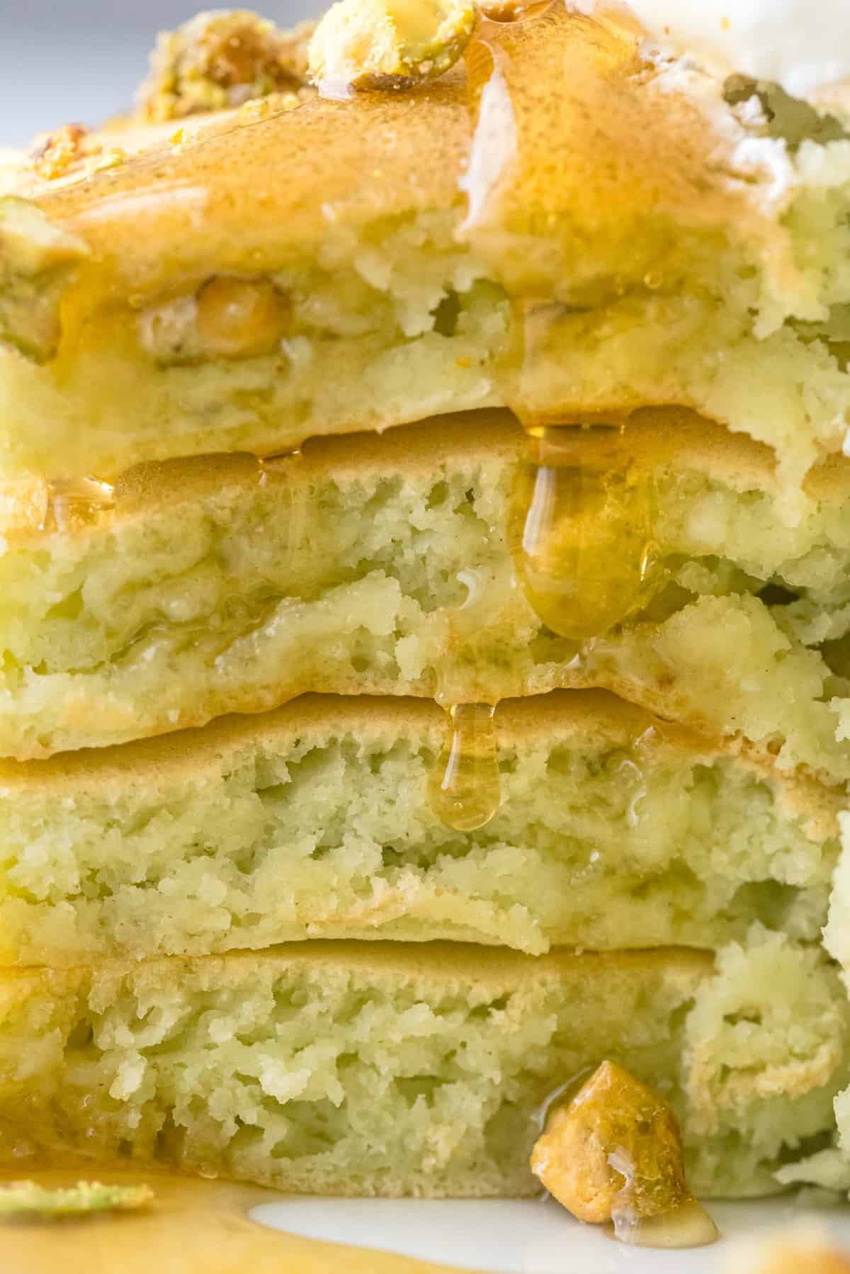 切开的煎饼上淋着糖浆的非常贴近的特写。