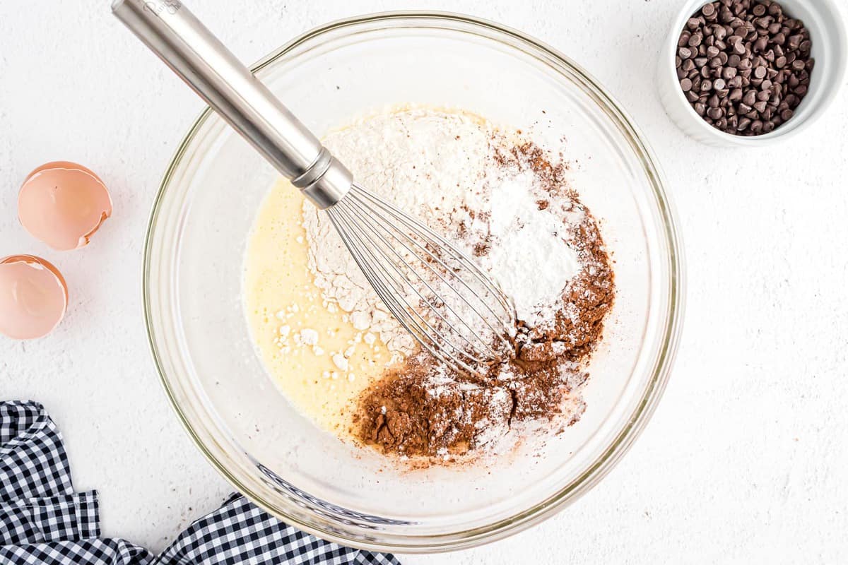 在一个玻璃搅拌碗中，湿成分上面撒上干成分，配以打蛋器。