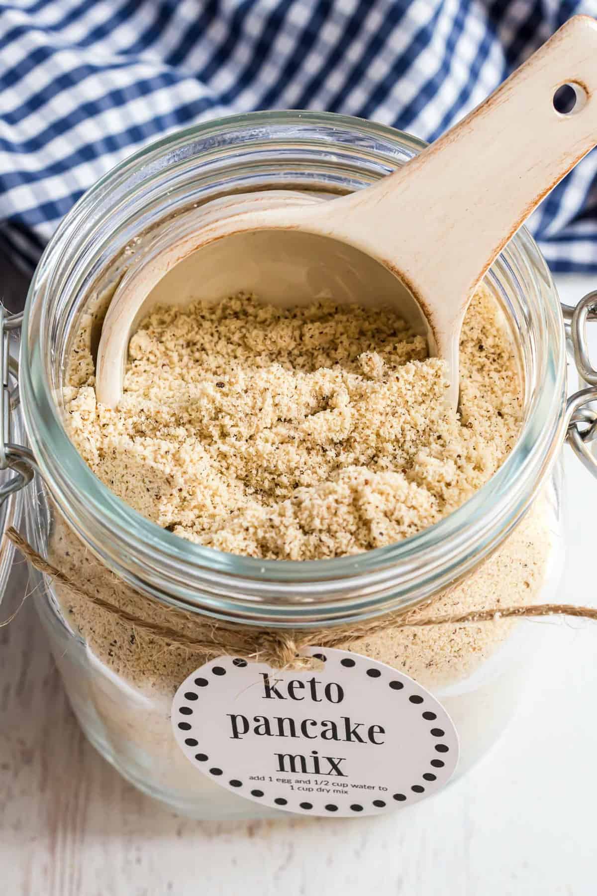 Pancake mix in a jar with large wooden scoop.